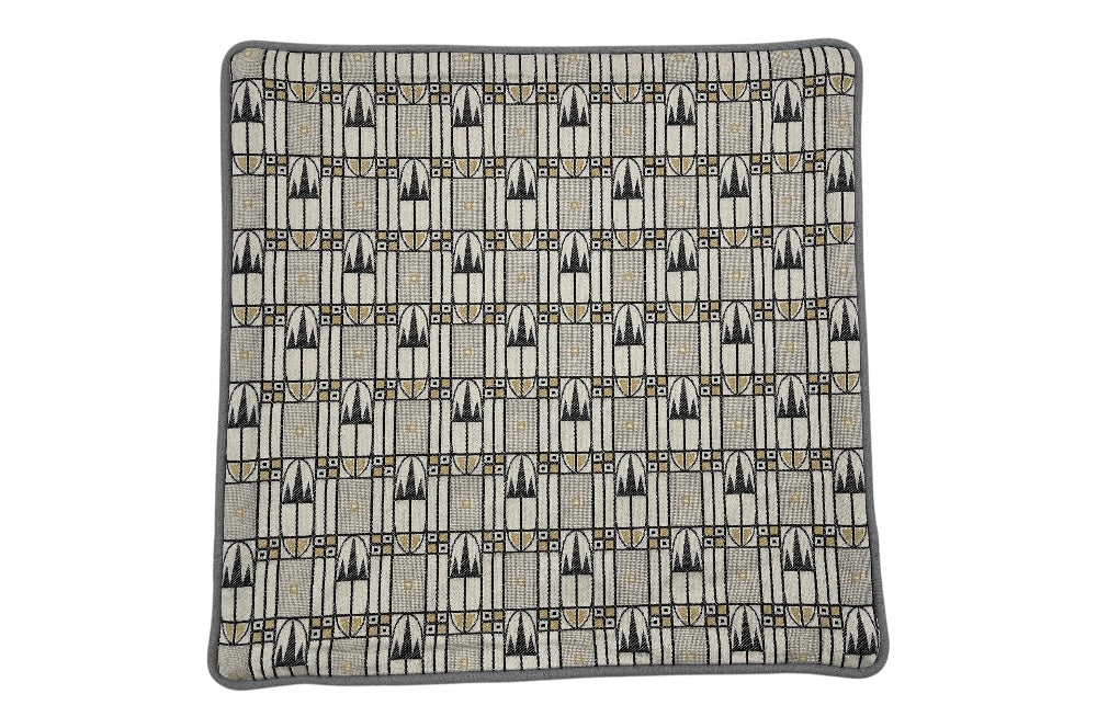 Zierkissen mit dem Bakhausen-Motiv „Zackenkrone“ in Beige, Schwarz und Grau. Das elegante Design wird durch einen unifarbenen Rückseitenstoff aus weicher Schurwolle ergänzt. 40x40 cm