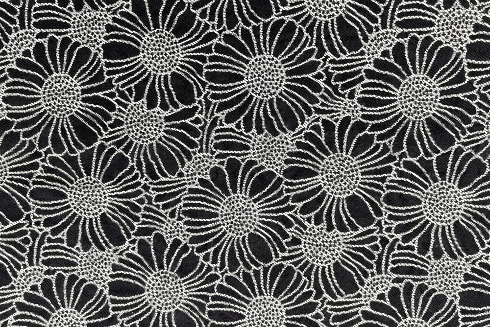 hochwertige Kissenhülle in Schwarz mit stilisiertem weißen Orakelblumen - detailansicht