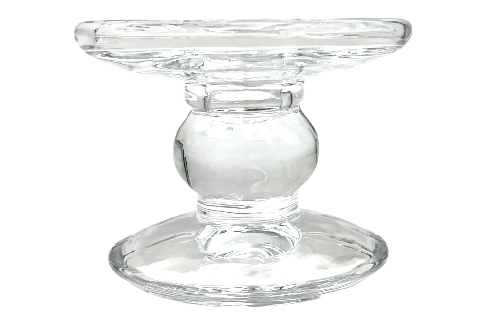 Eleganter Kerzenhalter aus klarem Glas mit geschwungener, schlanker Form. Die breite runde Basis sorgt für Stabilität, während die obere Vertiefung sowohl für Stumpen- als auch für Stabkerzen geeignet ist. Anischt von der Seite
