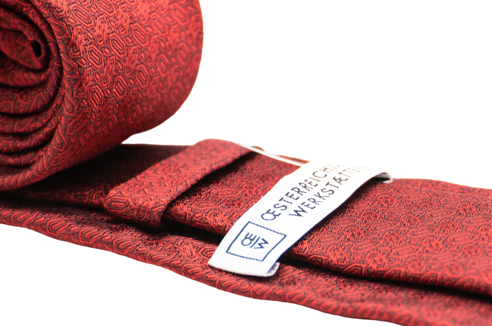 seidenkrawatte in rot mit diamantmuster, zusammengerollt, detailansicht logo oew