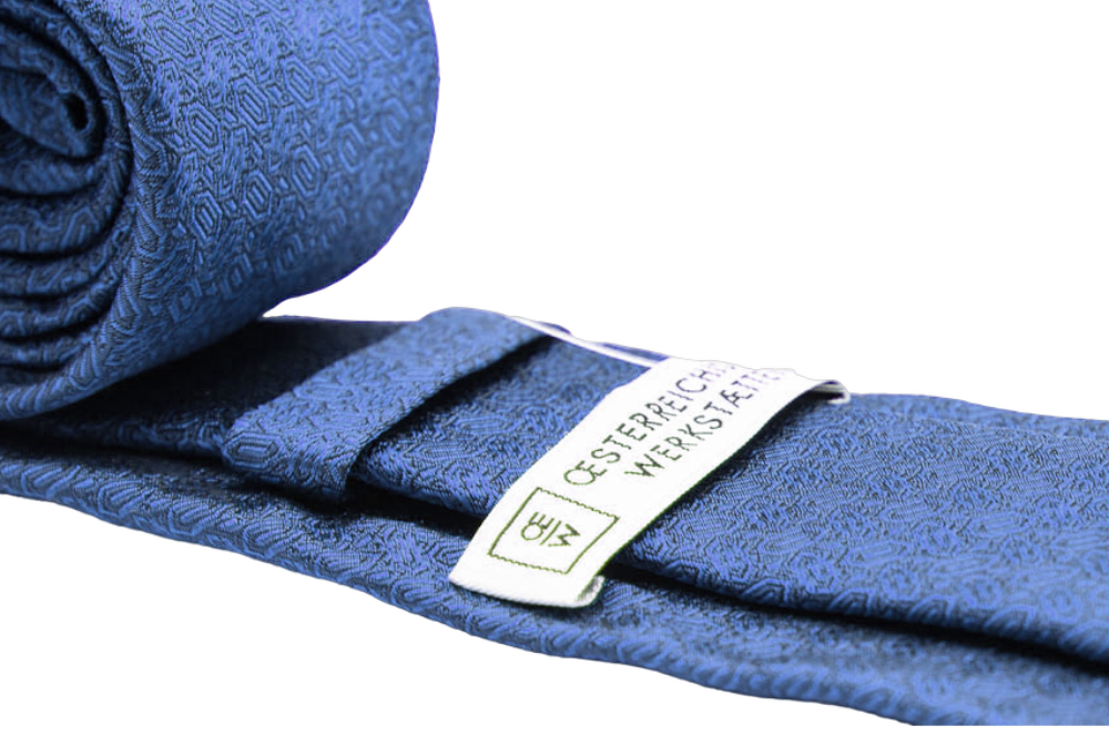 seidenkrawatte in blau mit diamantmuster, zusammengerollt, detailansicht, oew Logo