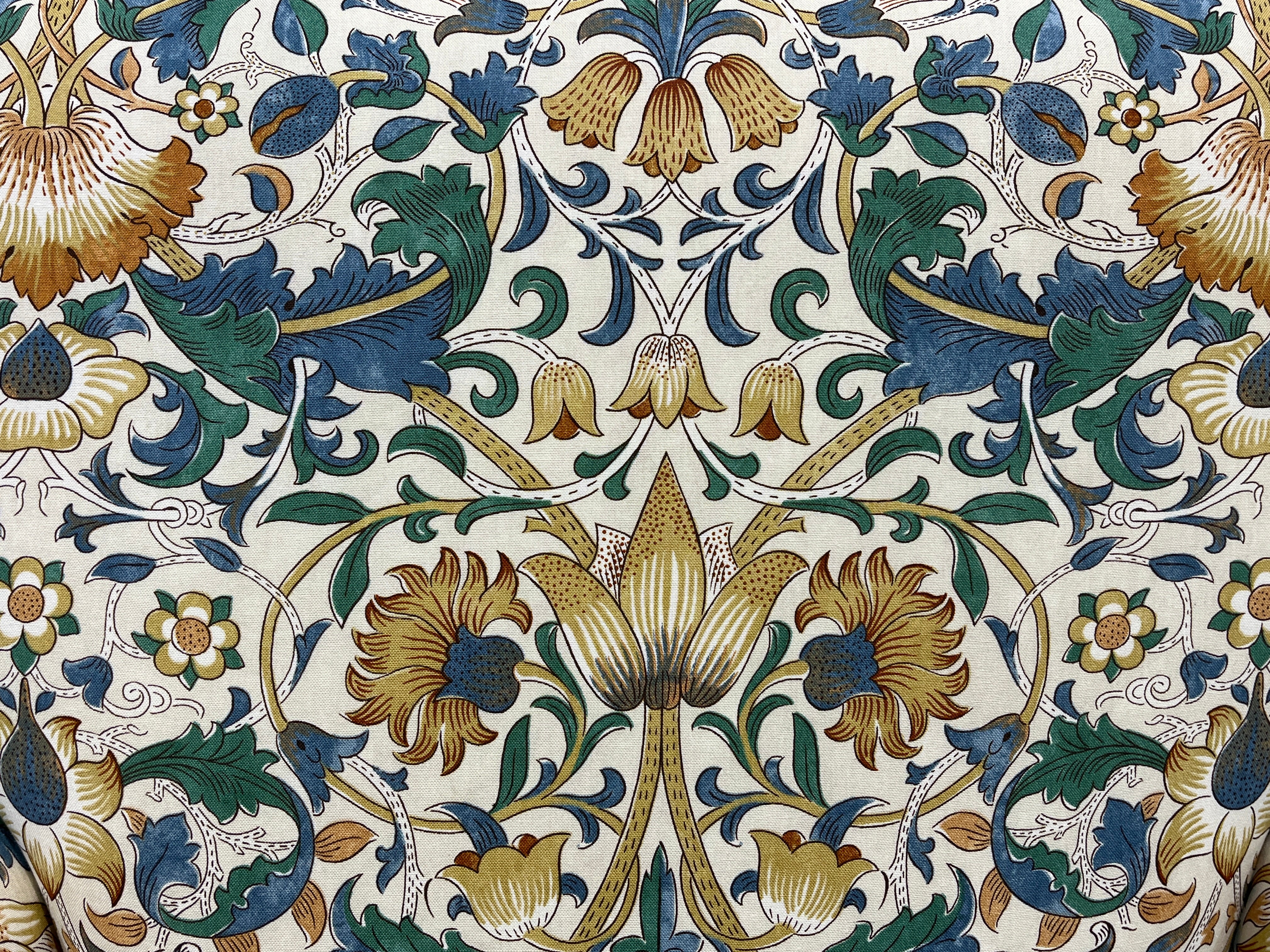 florale Muster aus Blumen, Ranken und Blättern in erdigen Tönen wie Gold, Grün und Blau.
