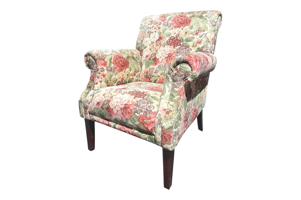 Klassischer Sessel mit floraler Polsterung in Sandersons „Rose & Peony“-Design, dunklen Holzbeinen und gepolsterten Rollarmen für eleganten Komfort. Ansicht von der Seite