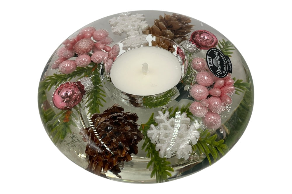 Teelichthalter aus Glas, mit rosa Perlen, Füchten, Fichtenzapfen,grünen Zweigen und weißen Schneesternen gefüllt. Ansicht von der seite