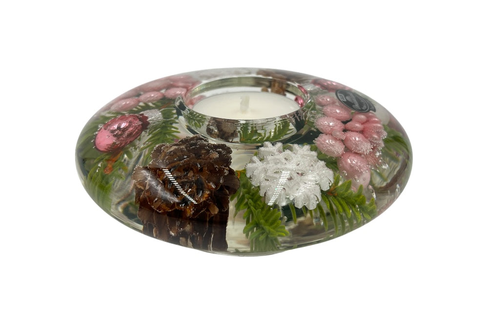 Teelichthalter aus Glas, mit rosa Perlen, rosa weihnachkugeln, Fichtenzapfen,grünen Zweigen und weißen Schneesternen gefüllt. Ansicht seitlich