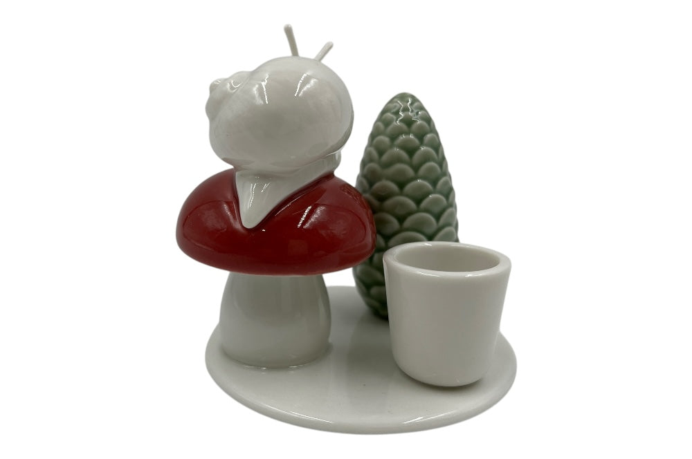 Weißer Herzenhalter mit einer kleinen Schnecke die auf einem roten Pilz sitz, daneben ein grüner ZapfenZapfen, Ansicht von hinten