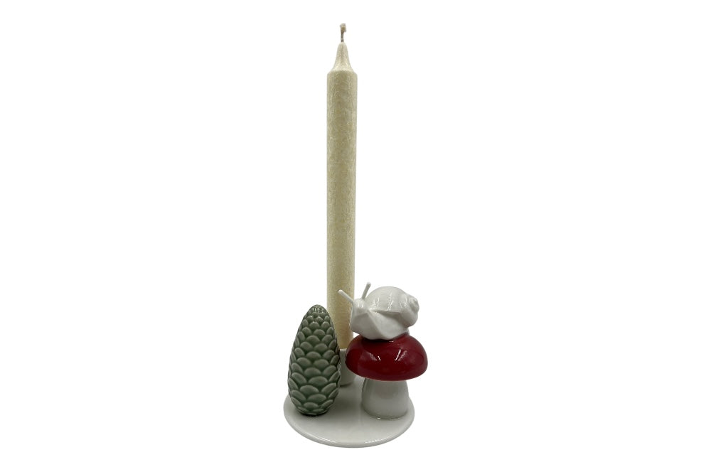 Weißer Herzenhalter mit einer kleinen Schnecke die auf einem roten Pilz sitz, daneben ein grüner ZapfenZapfen, Ansicht mit weißer Stabkerze