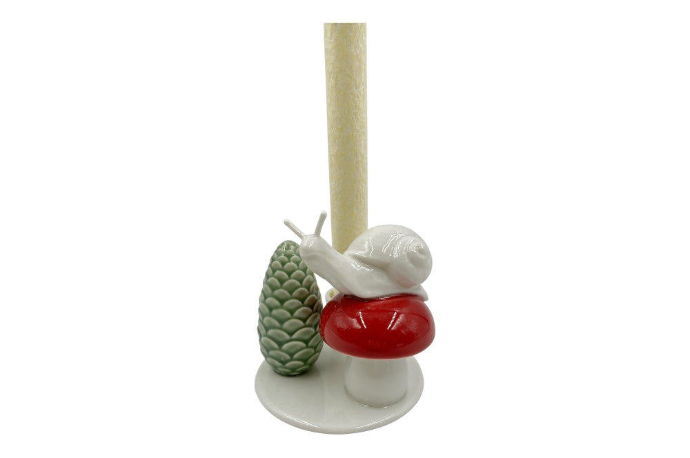 Weißer Herzenhalter mit einer kleinen Schnecke die auf einem roten Pilz sitz, daneben ein grüner ZapfenZapfen, Ansicht mit weißer Stabkerze, eingezommt