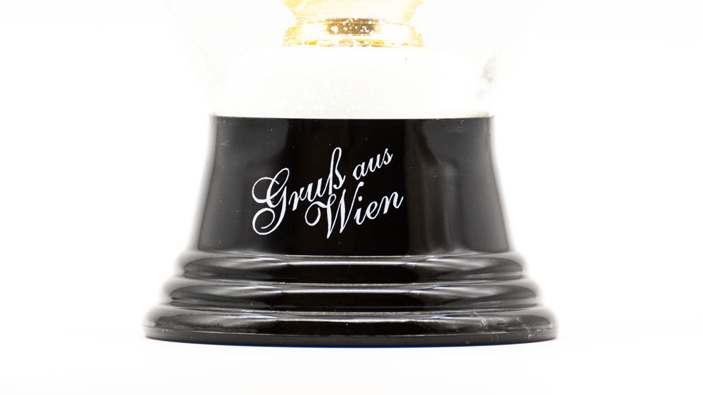 Sockel der Schneekugel Sachertorte mit Aufdruck "Gruß aus Wien" © LIK Akademie