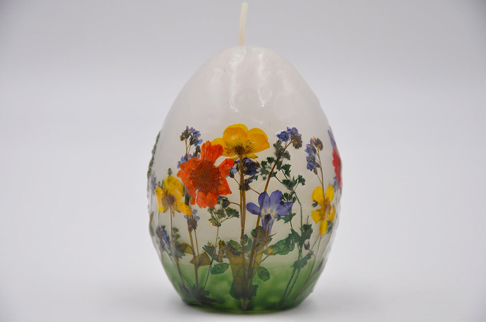 eifförmige kerze mit blumendeko