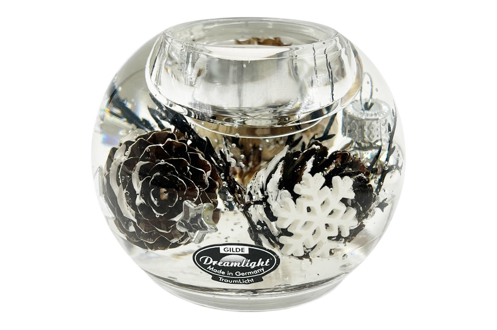 Teelichthalter aus Glas, mit weißen Christbaumkugelen, Kieferzapfen und weißen Schneesternen gefüllt. Ansicht von der seite